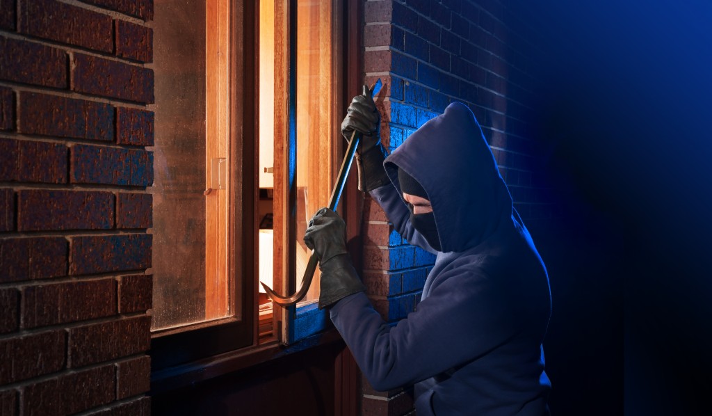 Burglar entering the house through a window