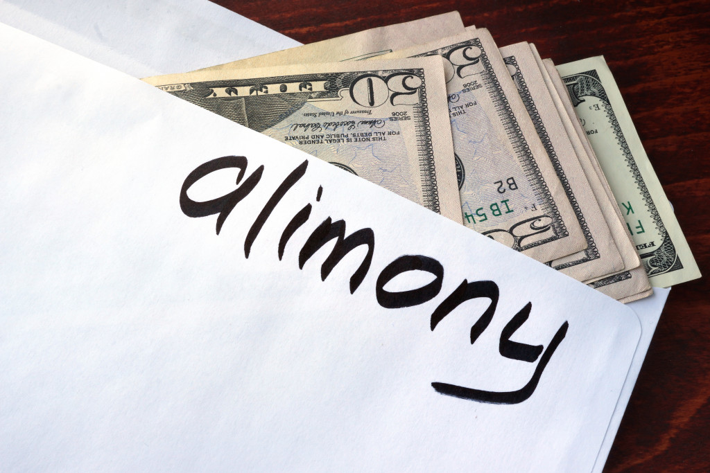 Cash sticking out of an envelope with Alimony on it