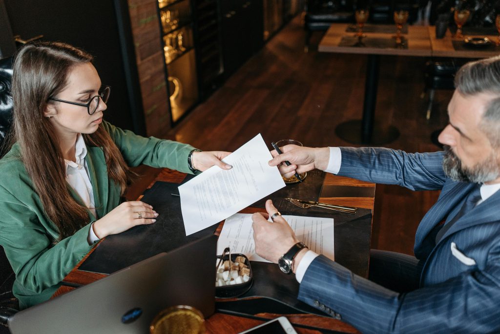 man giving paper to a woman