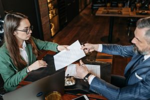 man giving paper to a woman